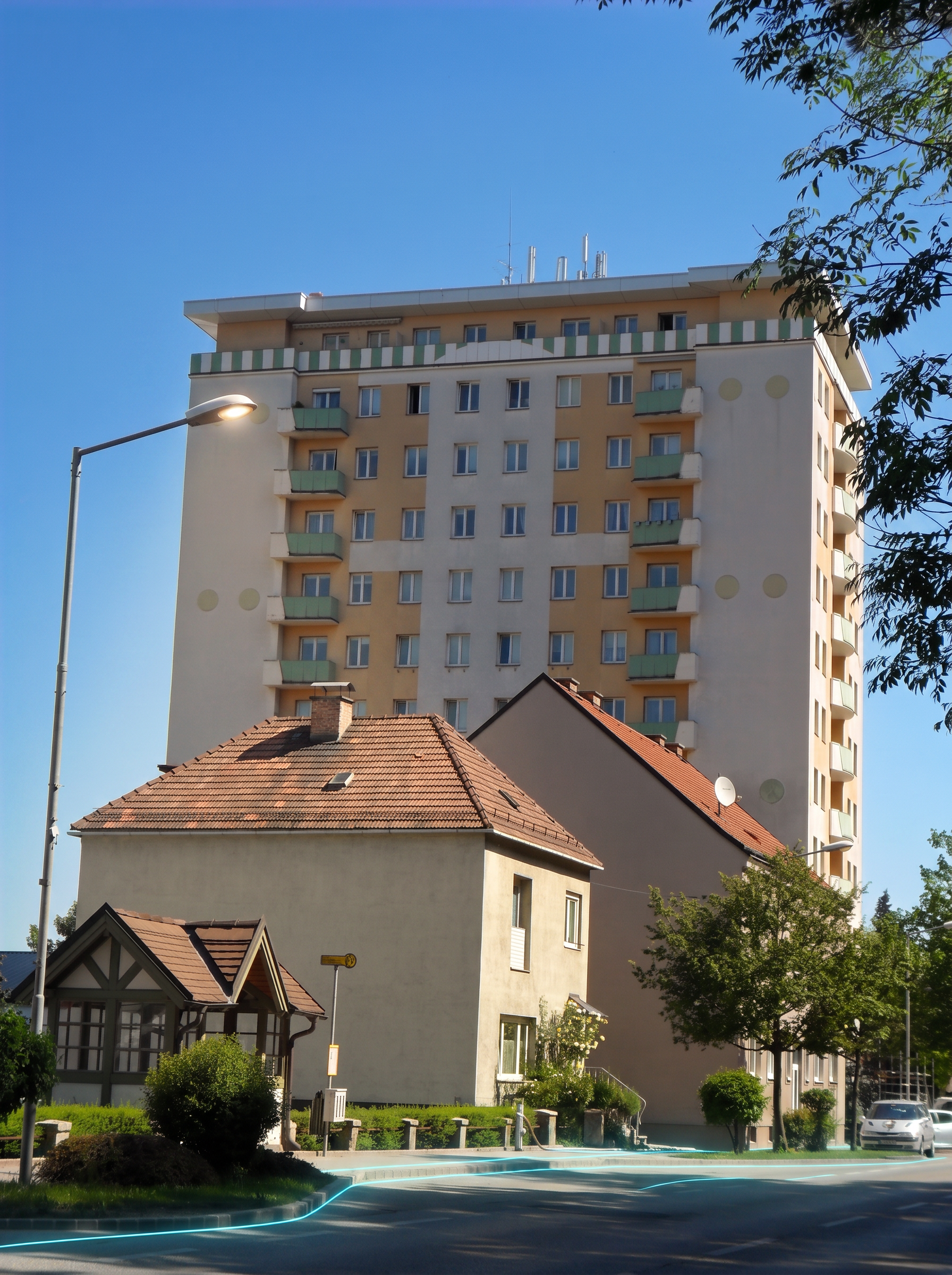 Hochhaus Wimpassing im Schwarzatale in warmem Abendlicht mit dezenten Glasfaser-Lichtlinien am Boden