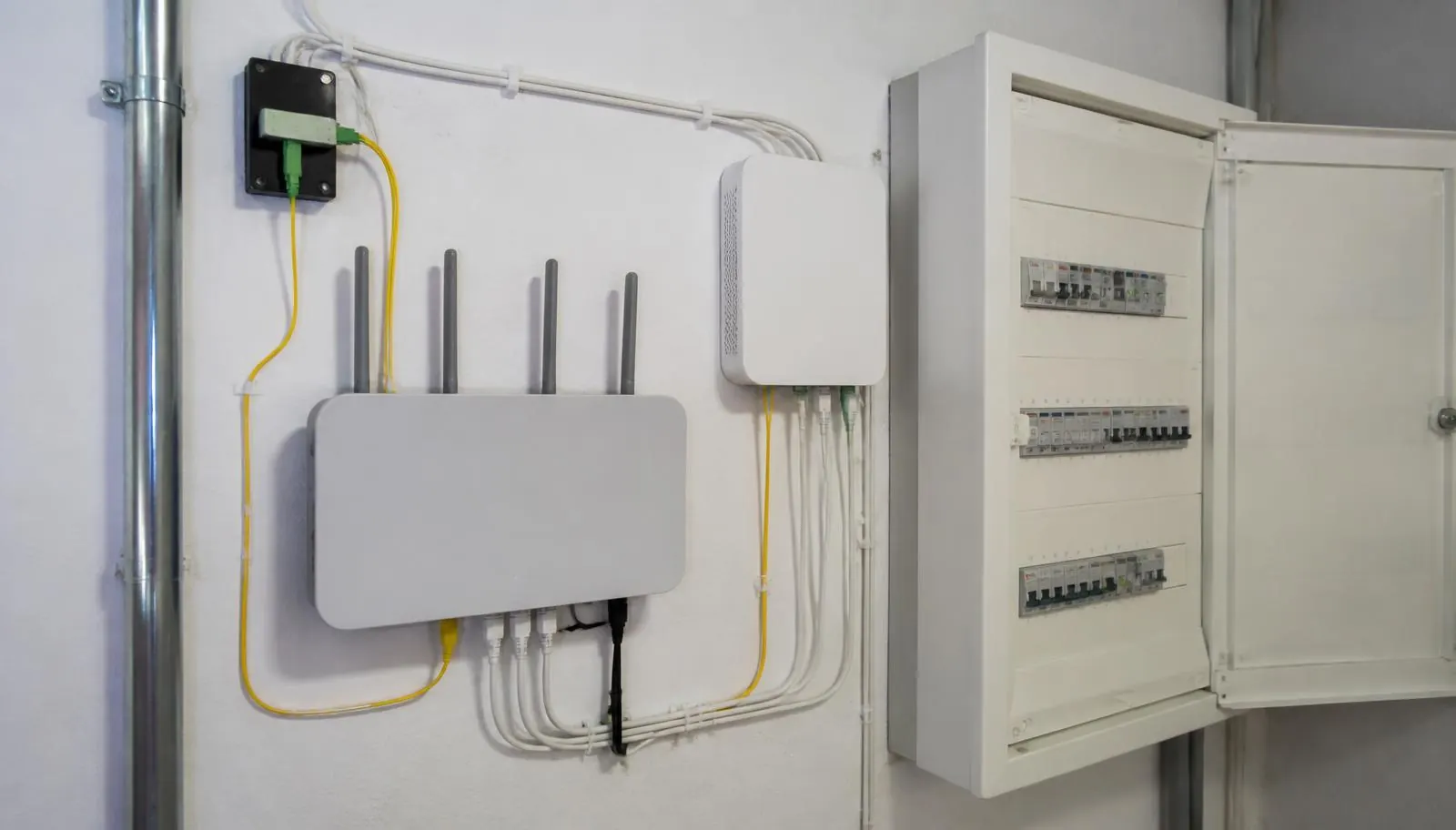 ONT und Router an der Kellerwand neben dem Sicherungskasten in einem Einfamilienhaus