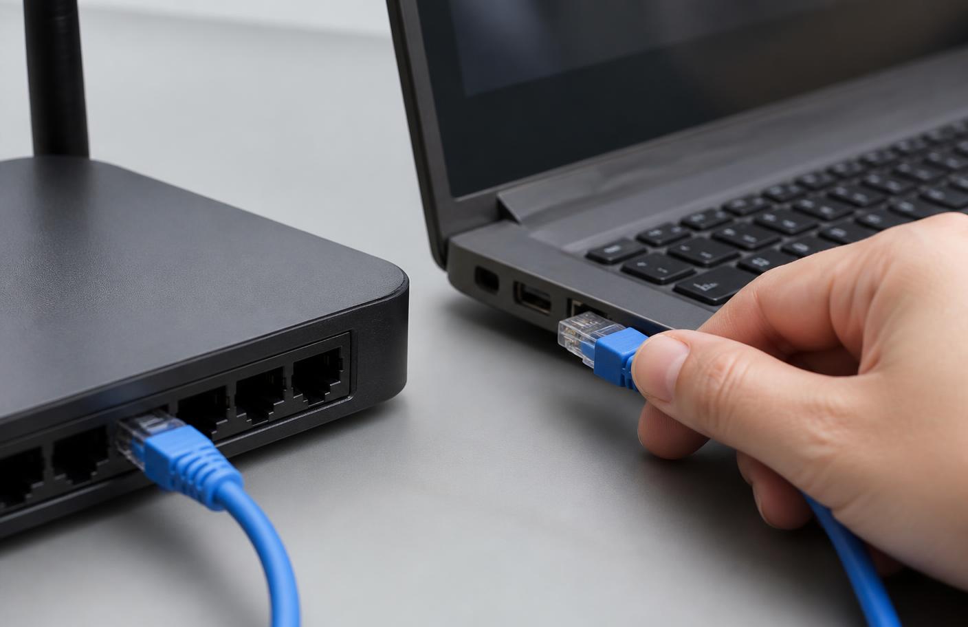 Netzwerkkabel wird direkt am Router in ein Notebook gesteckt
